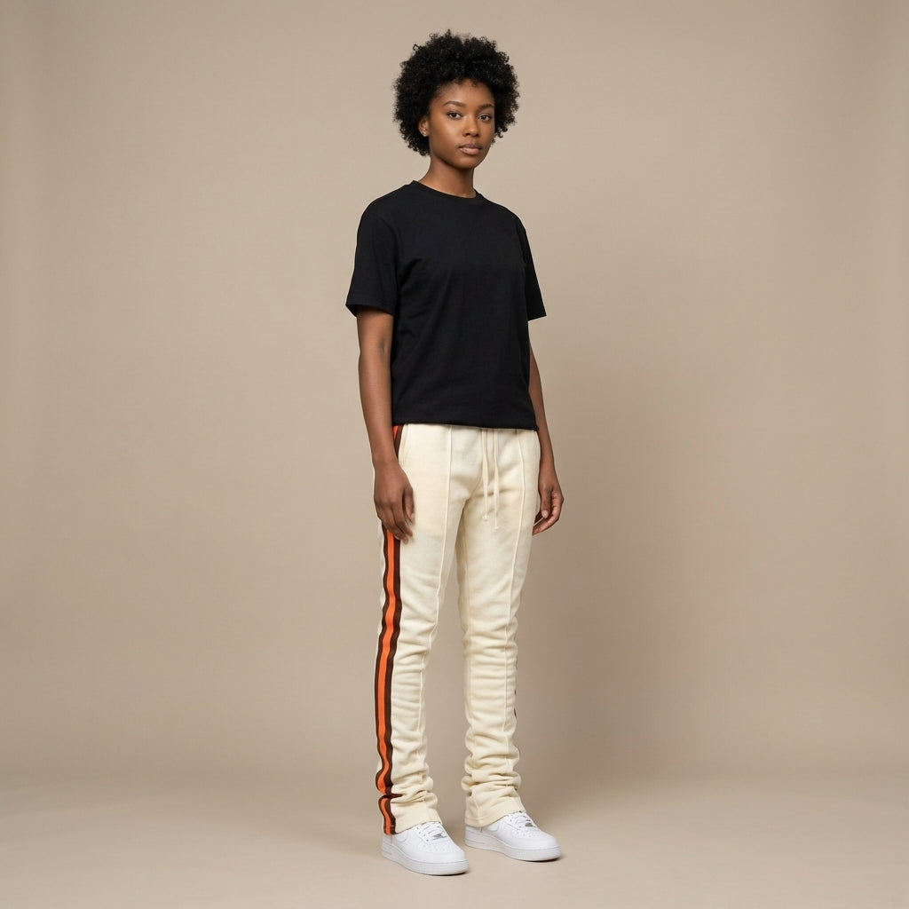Urban Flare Joggers in cream with orange side stripes, worn by a model standing against a neutral background.