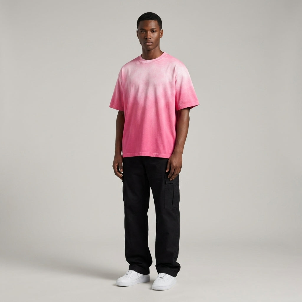 Person wearing a pink to black gradient t-shirt on a plain background