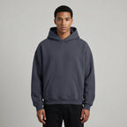 Blank heavyweight oversized hoodie in dark gray, featuring a front pocket and a spacious hood, worn by a model.