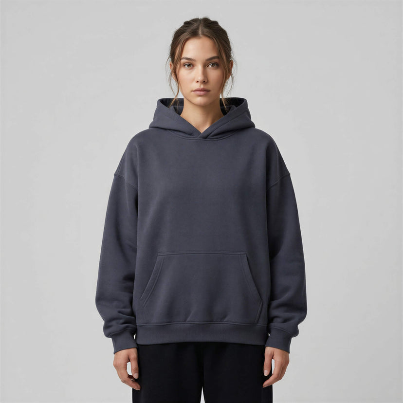 Heavyweight oversized hoodie in dark gray with a front pocket and adjustable drawstring hood, worn by a model.