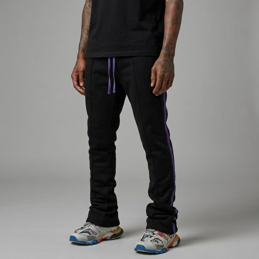 Urban Flare joggers in black with purple side stripes, worn by a person standing in a neutral background.