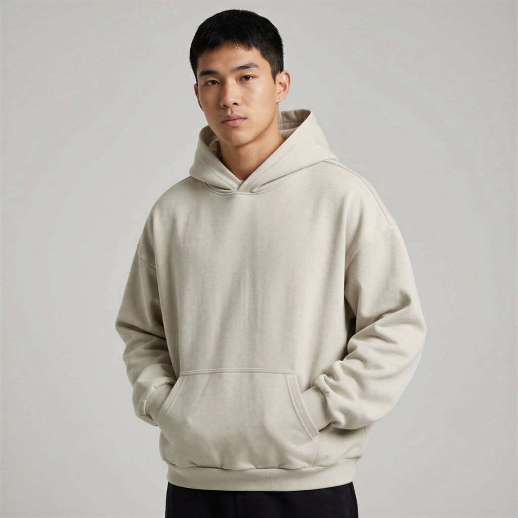 Blank heavyweight oversized hoodie in light beige, featuring a front pocket and adjustable drawstring hood.